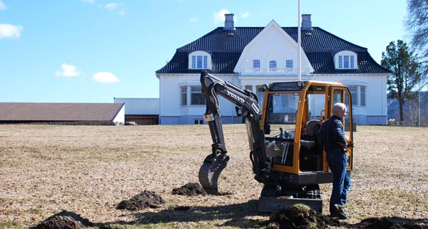 Foto av Thorbjørnrud med gravemaskin i forgrunnen